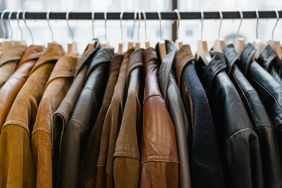 The Clothes of Winters A close-up view of leather jackets hanging neatly on a rack inside a store.