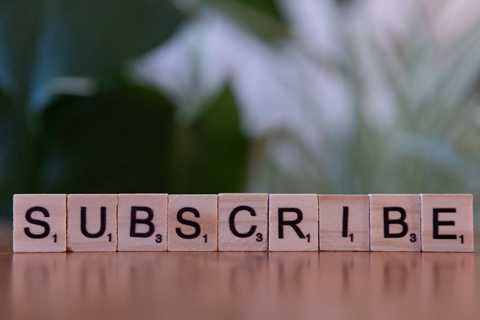 How to Promote Your Website on Kulfiy Platform Close-up of the word 'SUBSCRIBE' spelled with wooden letter tiles on a table.