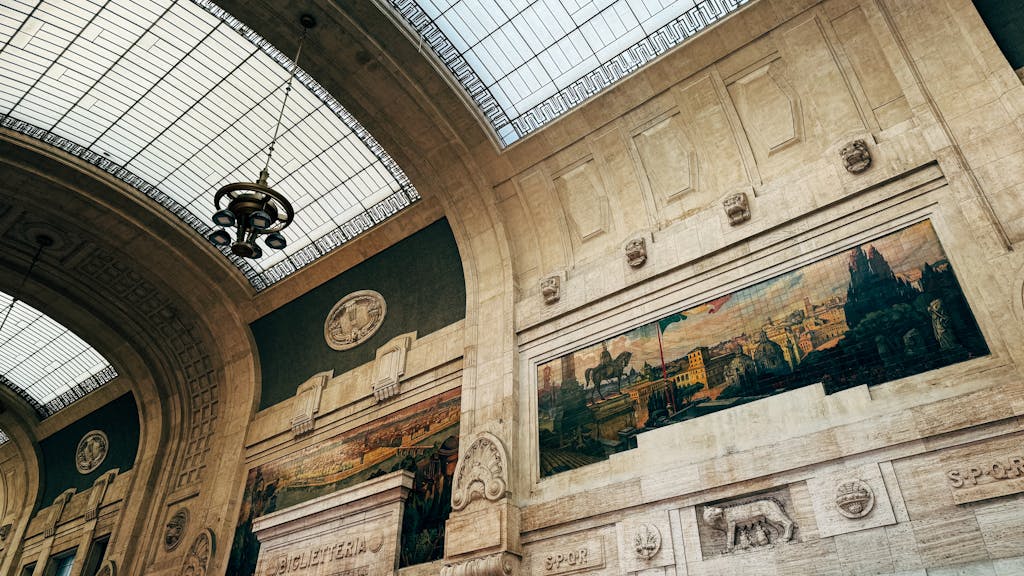 AC Milan vs SSC Bari Timeline Elegant architectural ceiling with historic artwork and stained glass in a classic railway station.
