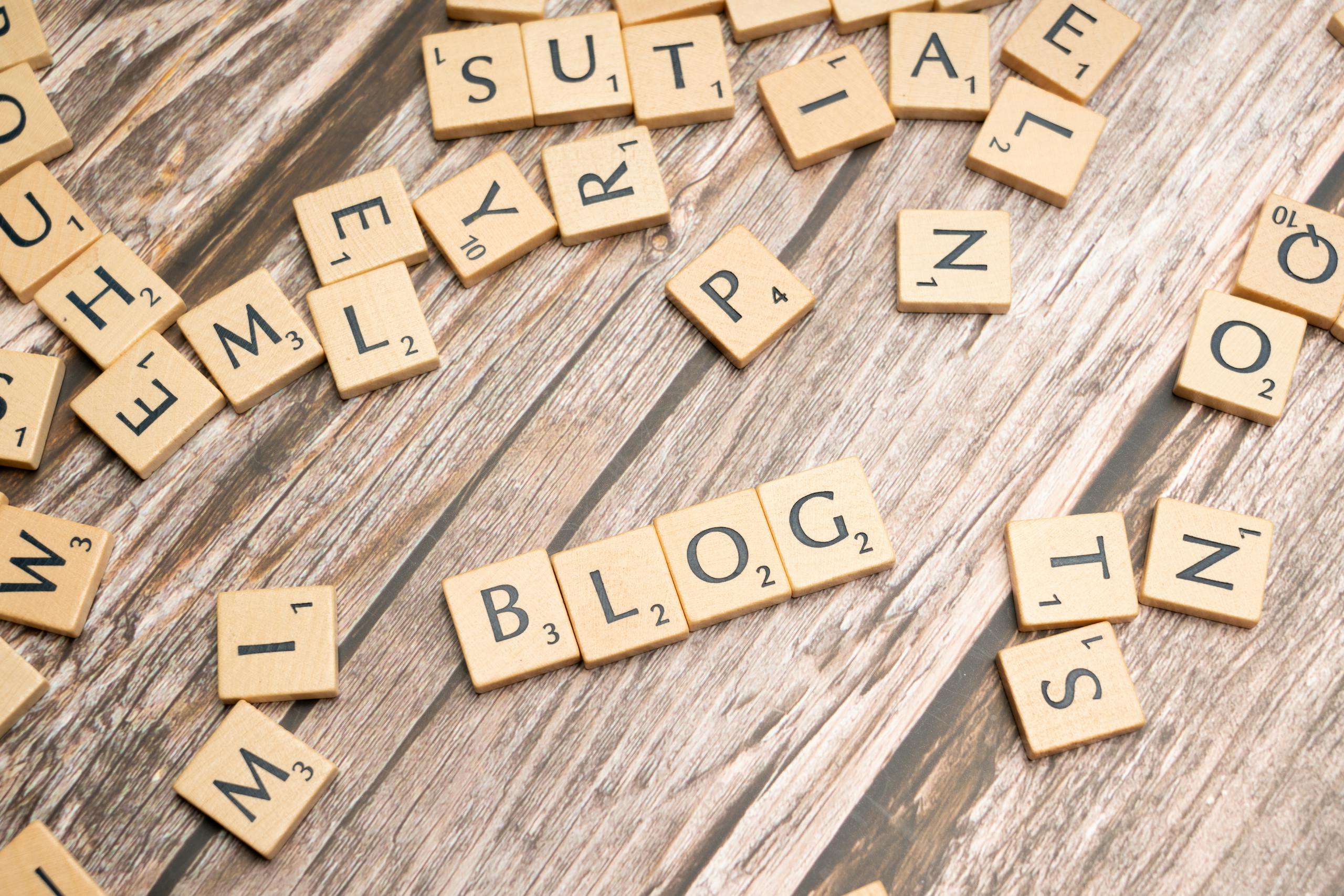 How to Promote Your Website on Kulfiy Platform Scattered wooden letter tiles spelling 'Blog' on a rustic wood background.