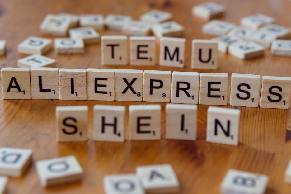 How to Promote Your Website on Kulfiy Platform Wooden Scrabble tiles display popular e-commerce platforms on a wooden surface.