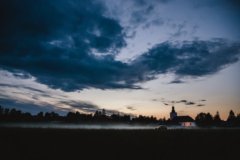 Serlig A dramatic sky over a quaint church in Dalarna County, Sweden at sunset.