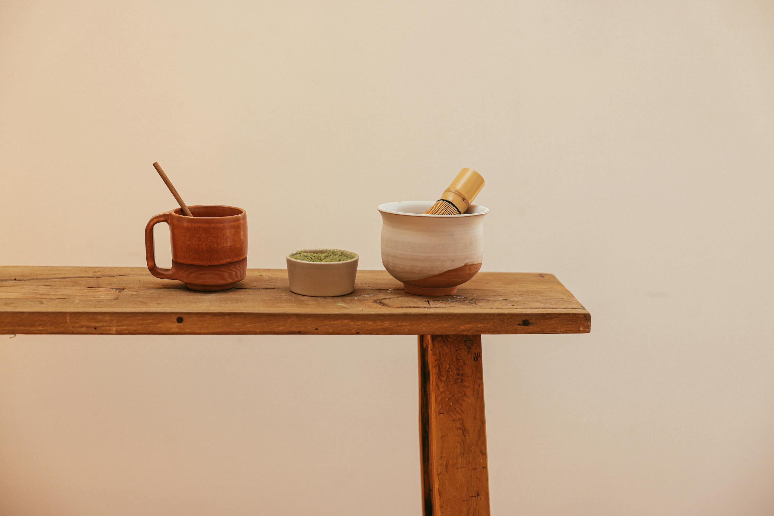 Bin Matcha A minimalist setup of matcha tea tools on a wooden table, perfect for serene tea moments.