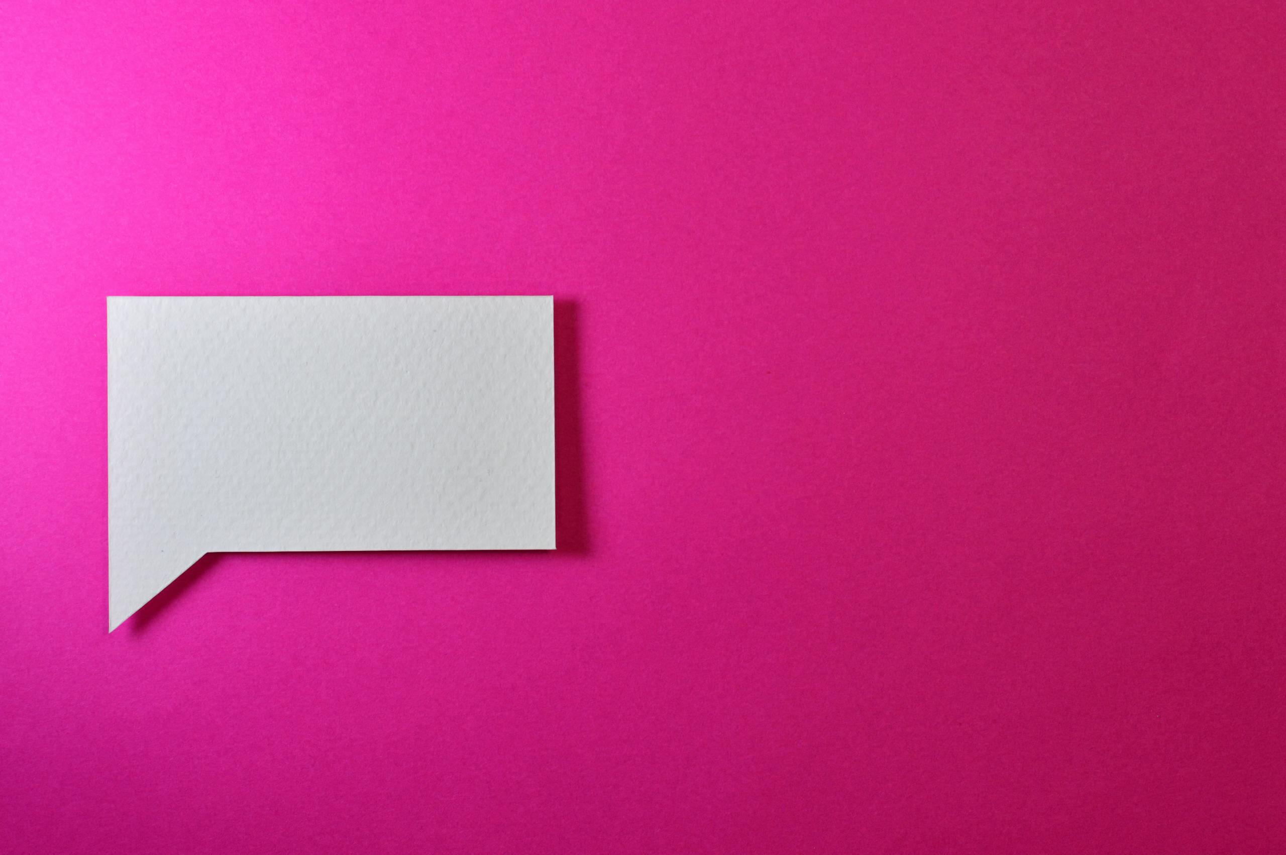 Xbocmy A minimalistic white paper speech bubble on a vibrant pink background, perfect for design projects.