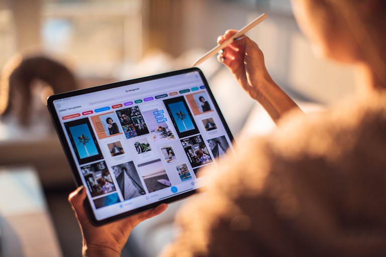 AcamentoA person u ses a digital tablet with a stylus indoors in a warm, cozy setting.