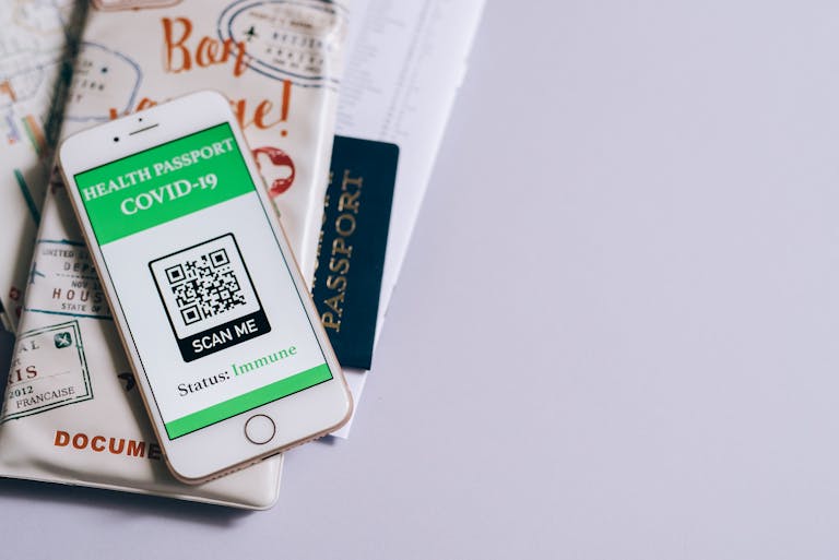 Roll QR Code Patch A smartphone with a COVID-19 health passport, passport, and travel documents indicating readiness for international travel.