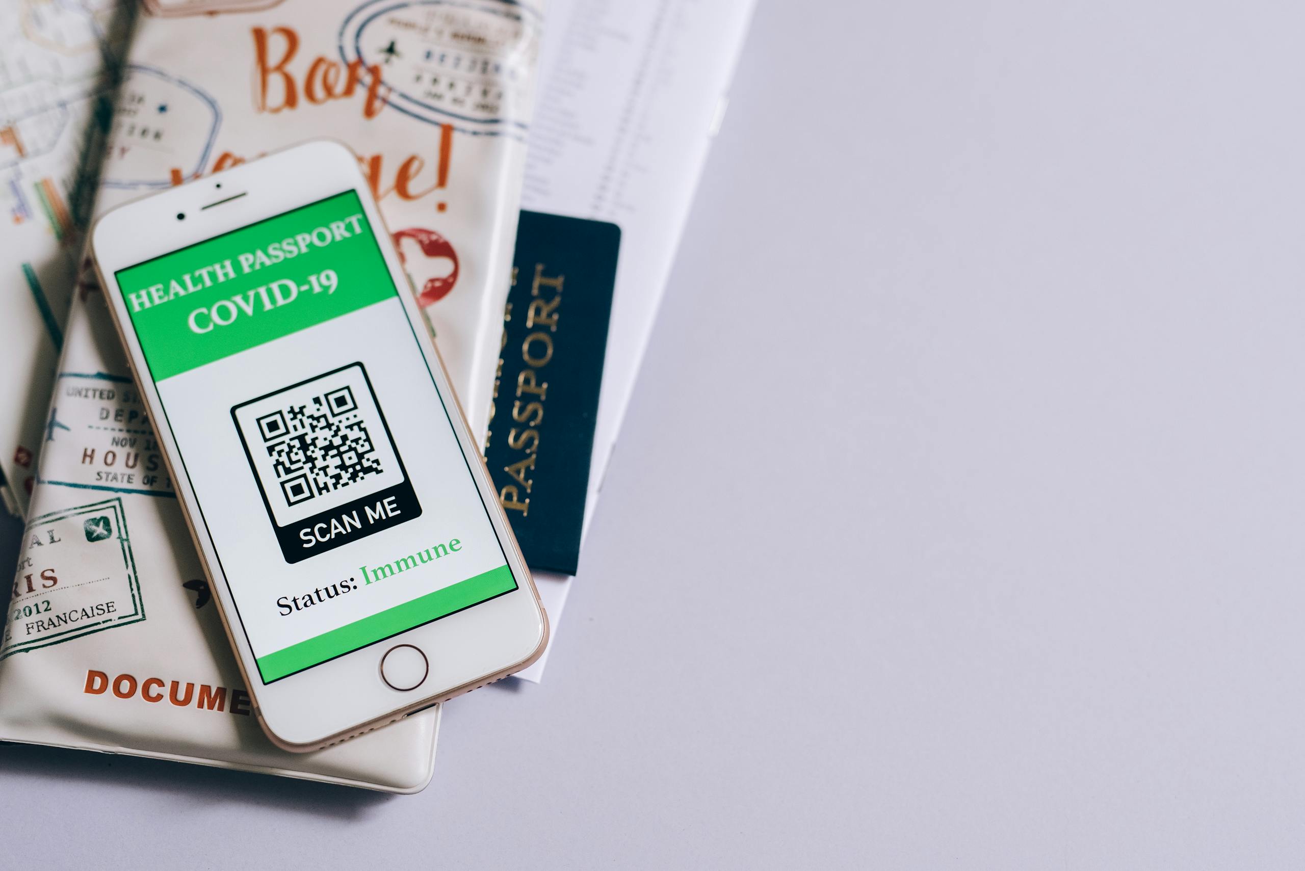 Roll QR Code Patch A smartphone with a COVID-19 health passport, passport, and travel documents indicating readiness for international travel.