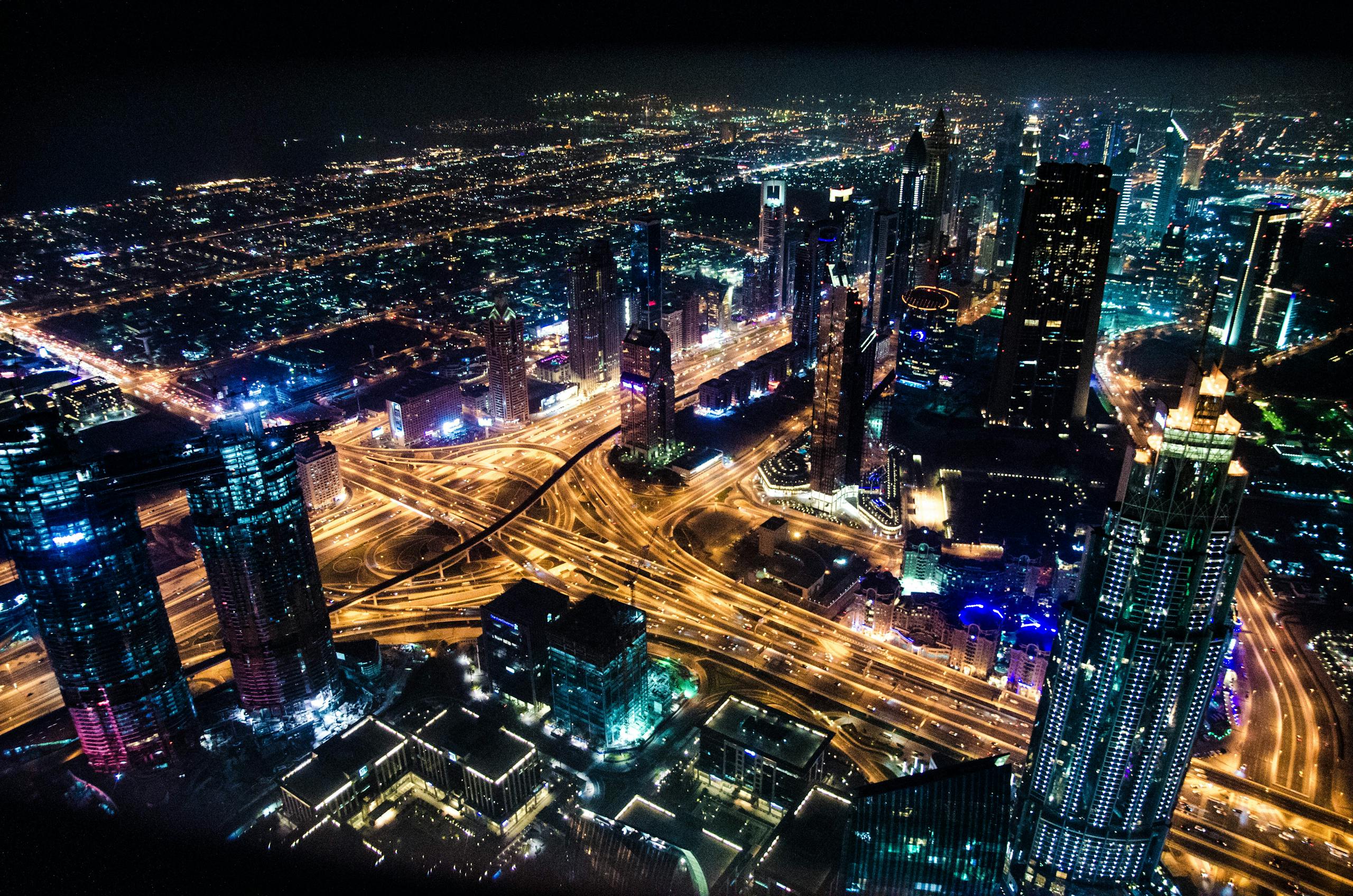 RWU UAR A stunning aerial view of Dubai's illuminated skyline at night, showcasing its modern architecture and busy roads.
