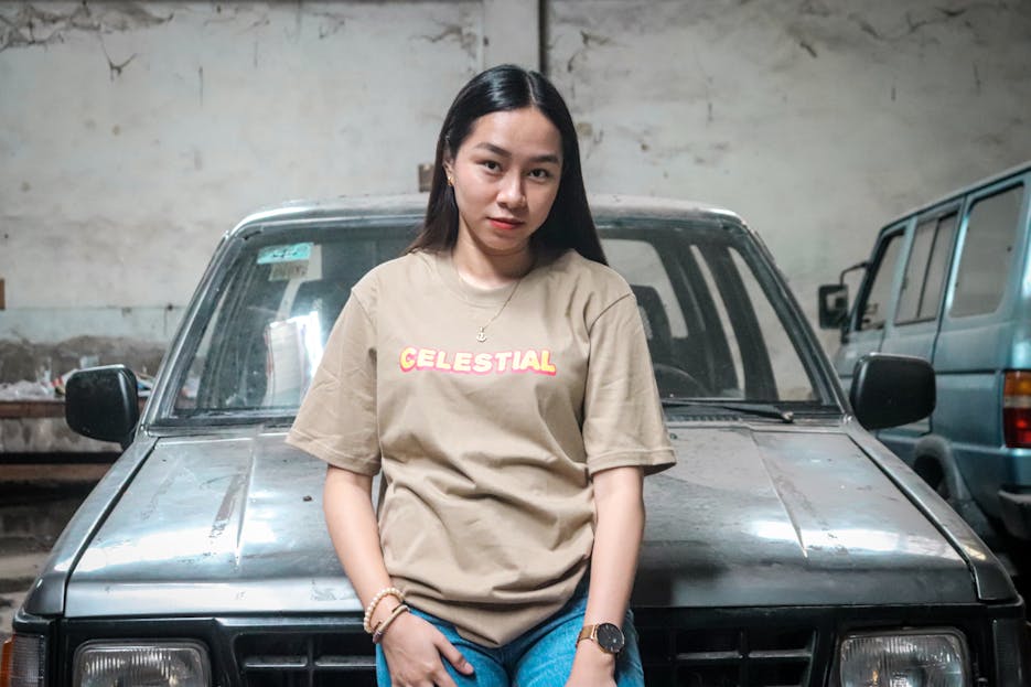 Asian Pinay  Asian woman in casual attire posing confidently in an urban environment against a car.