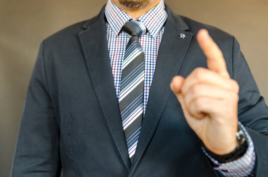 Blazertje Close-up of a man in a suit making a gesture, symbolizing instruction or guidance.