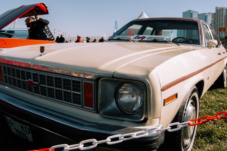 Nova Scola Close-up of a vintage beige Chevrolet Nova at an outdoor auto exhibition.