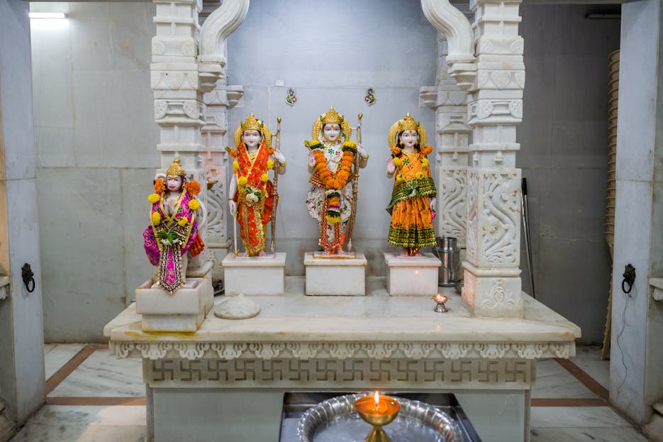 Shri Hanuman Dham Decorative Hindu deity statues adorned with flowers inside a traditional Mumbai temple.