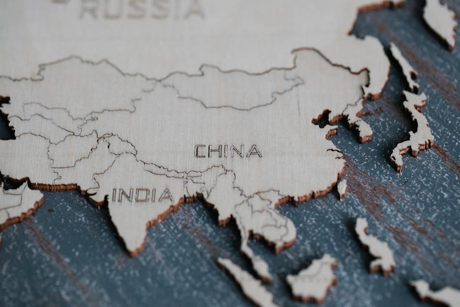 China Help Russia Detailed view of Asia carved on a wooden map, highlighting China and India.