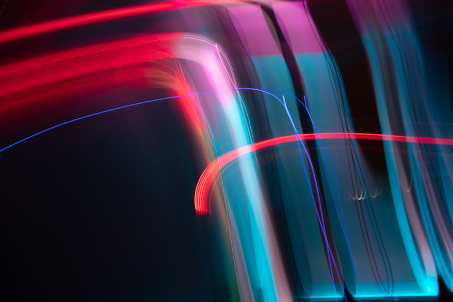 DainikShiksha.com Dynamic and colorful long exposure light streaks in an abstract artistic composition.