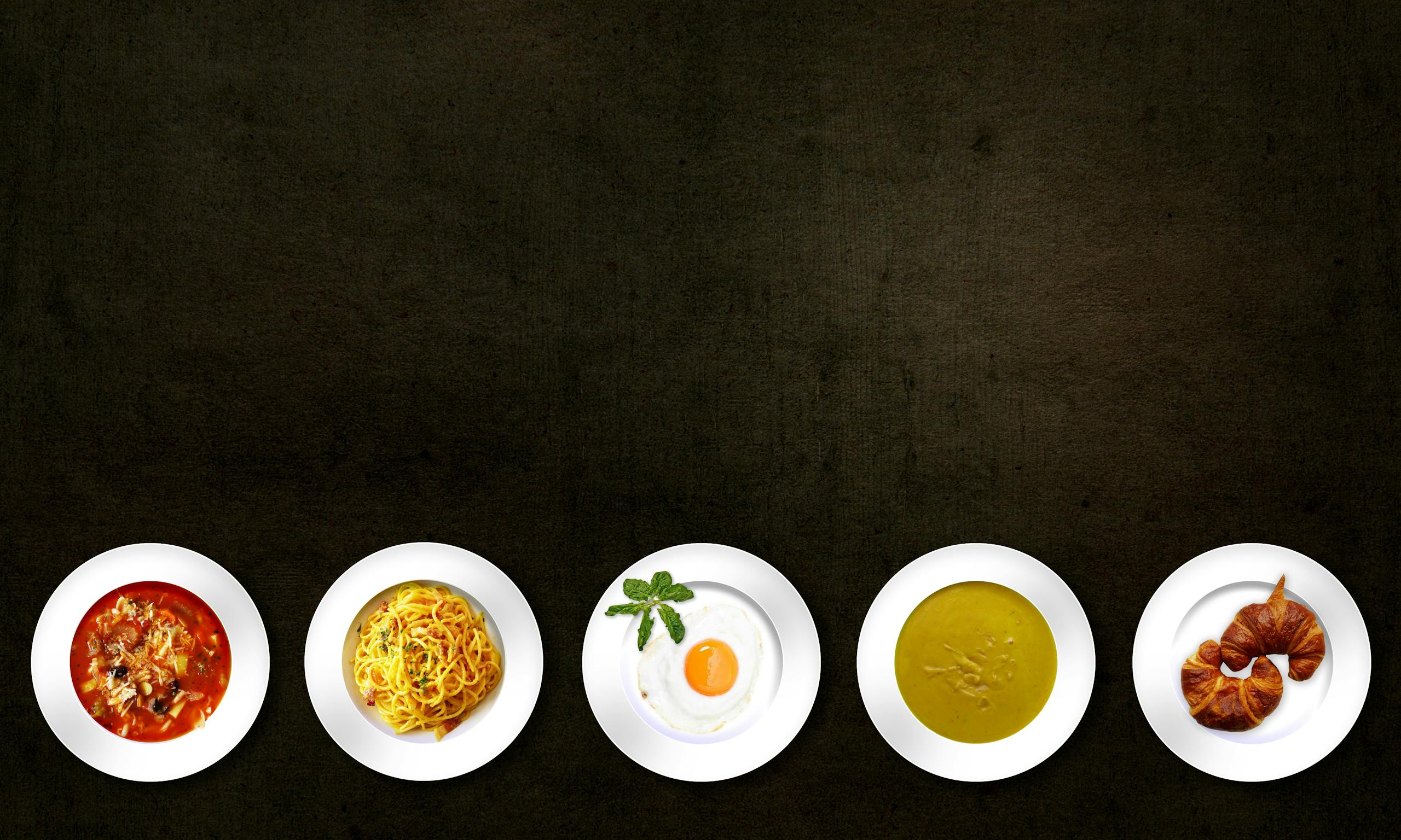 Monika Leveski Flatlay of various dishes including pasta, egg, soup, and croissant on textured background.
