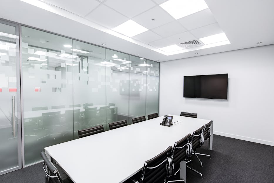 Cartetach Sleek, minimalist conference room with glass walls, long table, and office chairs.