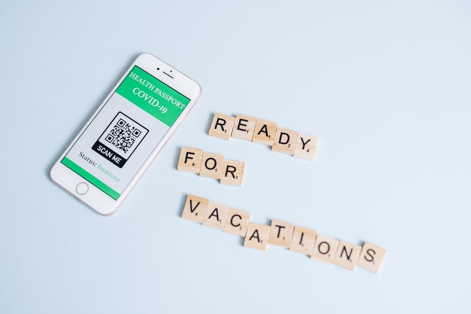 Roll QR Code Patch Smartphone displaying COVID-19 health passport next to Scrabble letters spelling 'Ready for Vacations' on a pastel background.