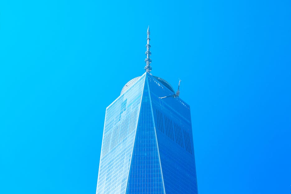 Bitni Spirs Striking view of One World Trade Center soaring into a cloudless blue sky in New York City.