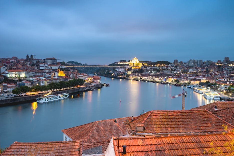 NovaPG Stunning view of Porto cityscape and Douro River at twilight, highlighting Portugal's architectural beauty.