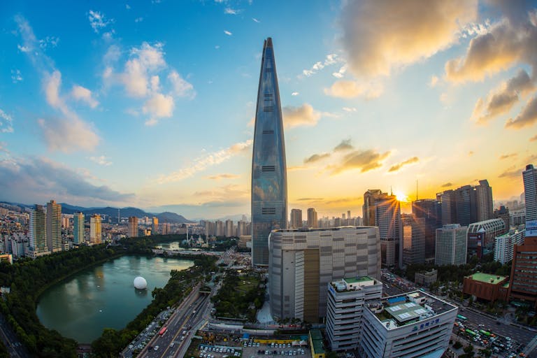 Koriandri Stunning view of Seoul's skyline featuring Lotte World Tower at sunset.