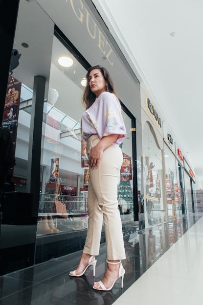 Babyfied Apparel Stylish woman in a shopping mall corridor showcasing contemporary fashion.