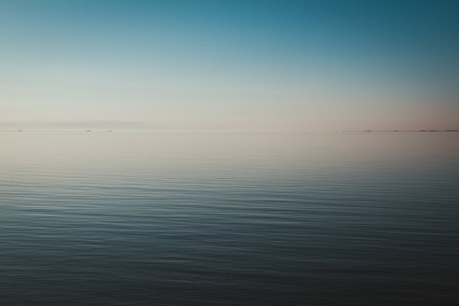 Wattip Tranquil seascape view at dawn with calm waters and a clear horizon.