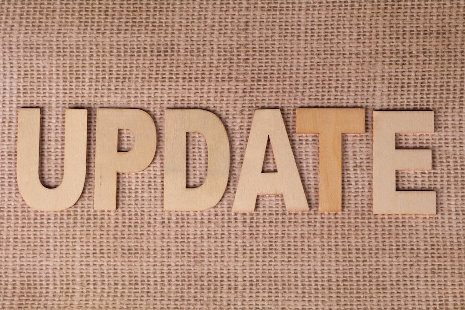 Dainik Shiksha Update News Today: Wooden letters arranged to spell 'UPDATE' on a textured burlap surface, perfect for business or project imagery.