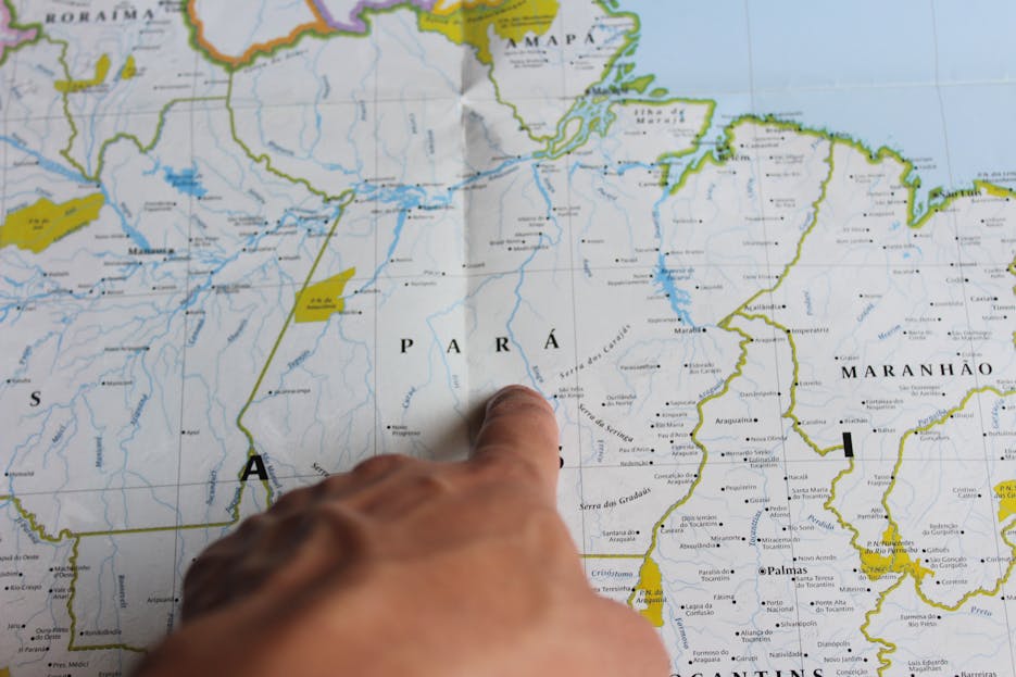 630 Area Code A close-up of a hand pointing at the state of Pará on a map of Brazil.