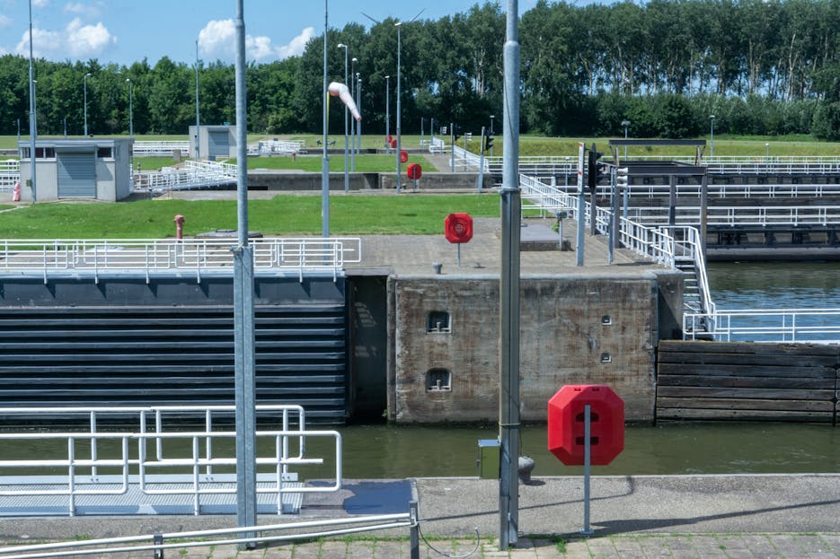realize infrastructure navigator  A modern canal lock system featuring safety buoys and lock gates on a sunny day.
