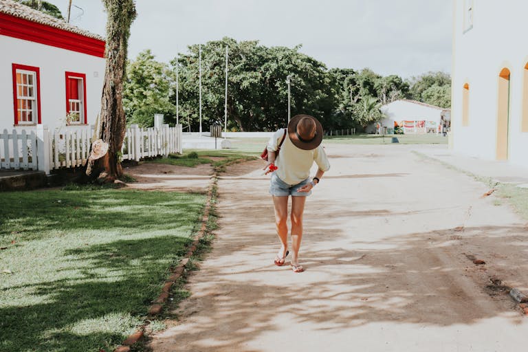 juntos seguros ice A woman in casual attire walks down a sunny street in Porto Seguro, Bahia, Brazil.