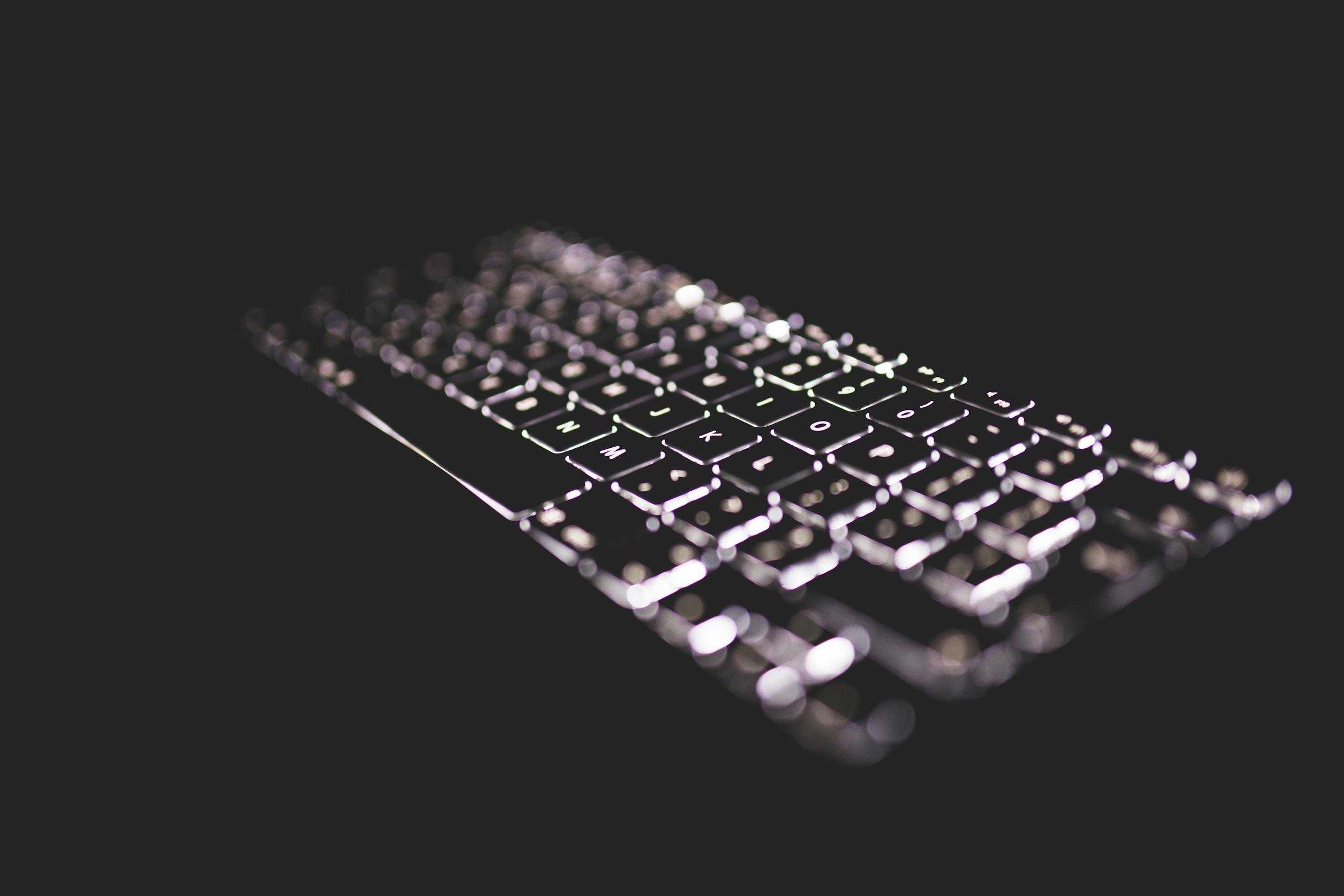 whatsontech Close-up of a glowing keyboard with backlight on a dark background, emphasizing technology.