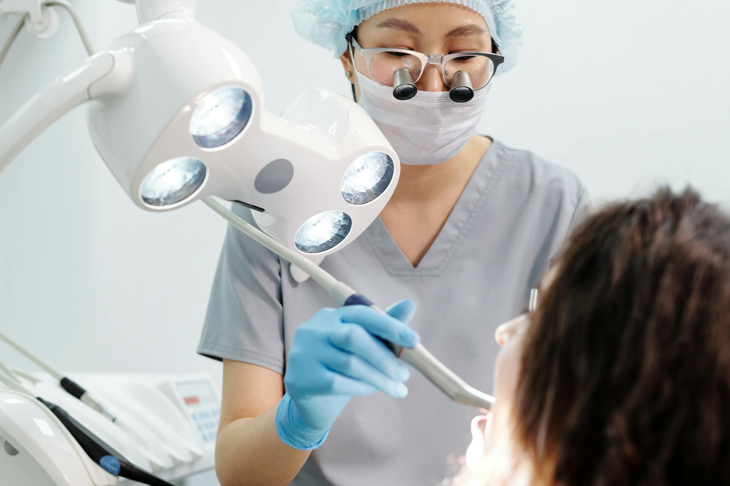 Dental Software News Todayb Dentist using tools and lights during a dental examination procedure in a modern clinic.