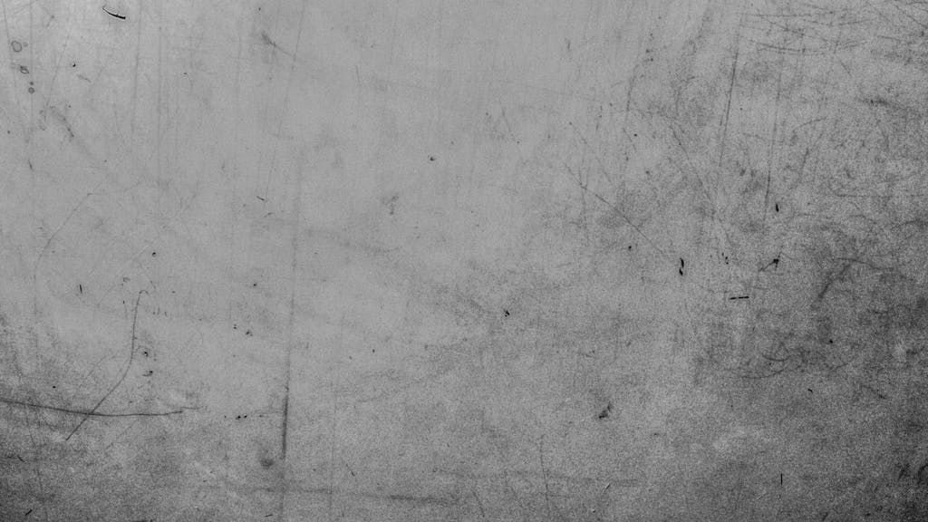 Emfyteymata Detailed view of a textured grey surface with visible scratches and marks.