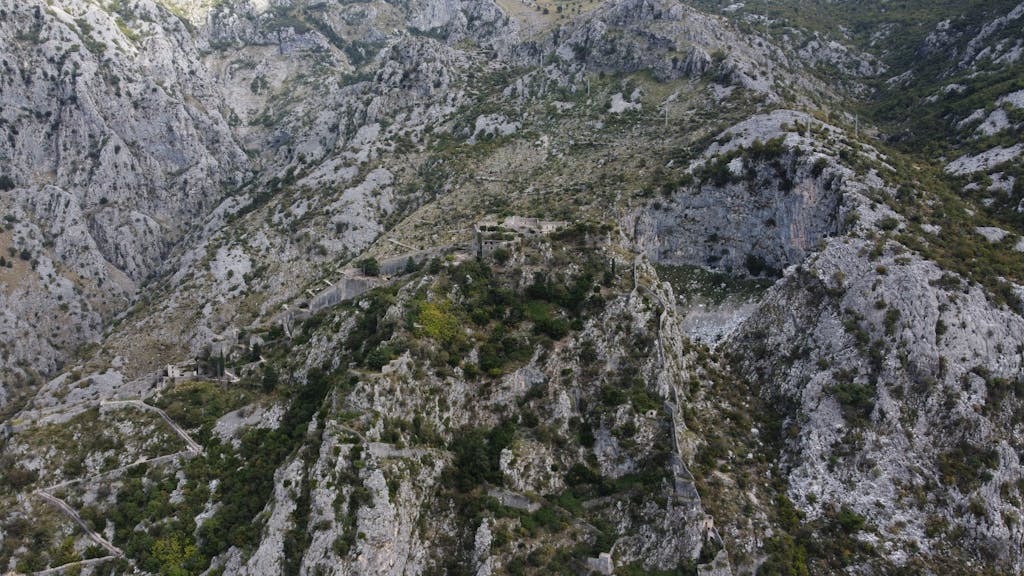 Kulfiy com Drone shot revealing historic fortifications set against Montenegro's rugged terrain.