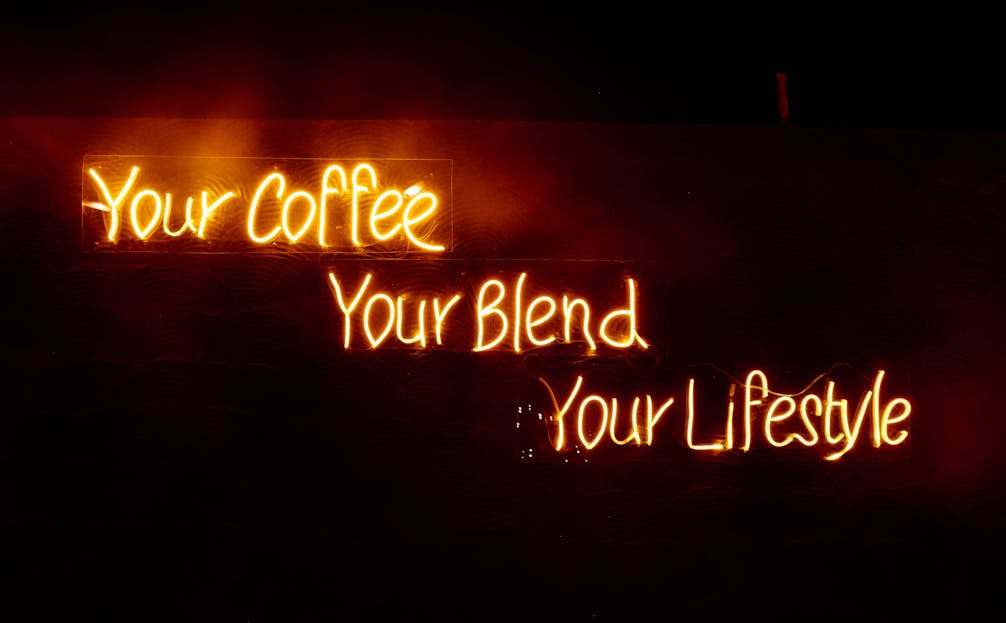 Shop Spring Vase Glowing neon sign saying 'Your Coffee, Your Blend, Your Lifestyle' in warm tones, perfect for cafes.