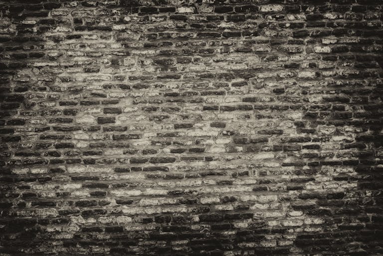 Newstook Grayscale textured brick wall background with rough surface.