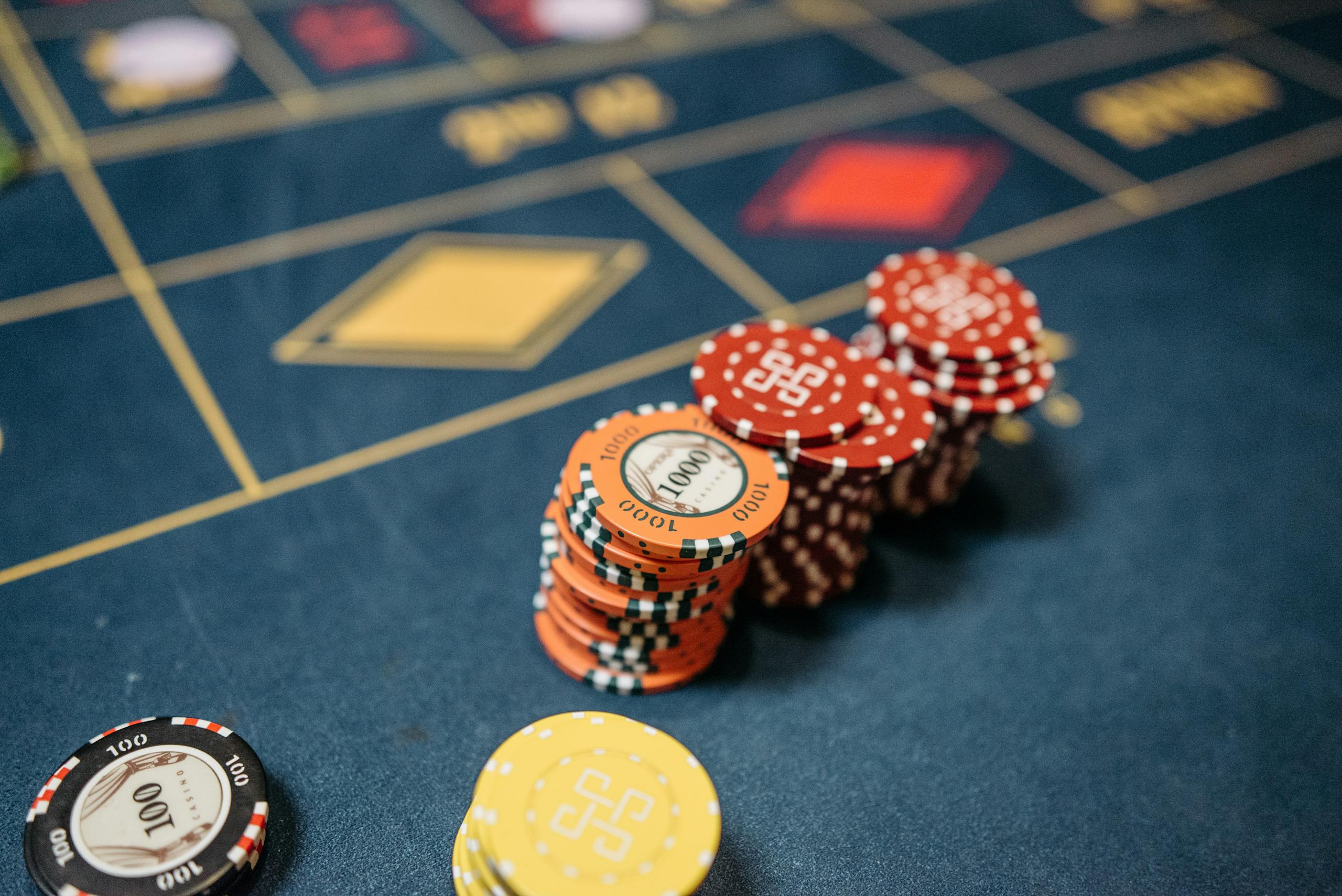 norsk casino www ribitup com Stacked casino chips on a vibrant roulette table, symbolizing chance and gaming excitement.