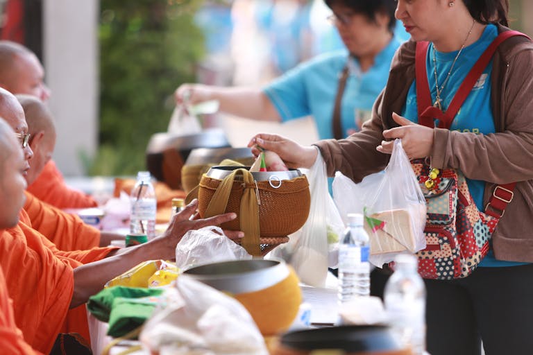 Pak vs Ind Women offer food and essentials to Buddhist monks in a traditional alms ceremony in Thailand.