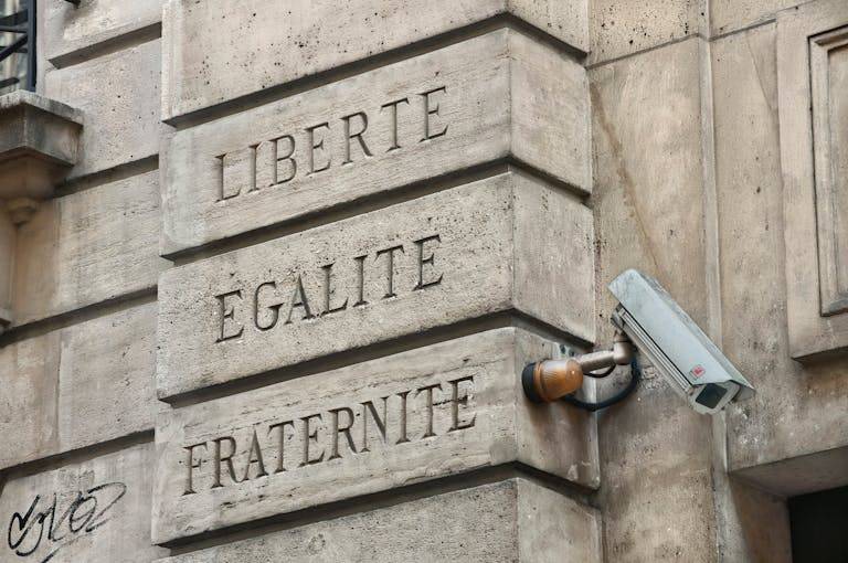 IPLLeague2026 A Parisian wall with 'Liberté, Égalité, Fraternité' and security camera.