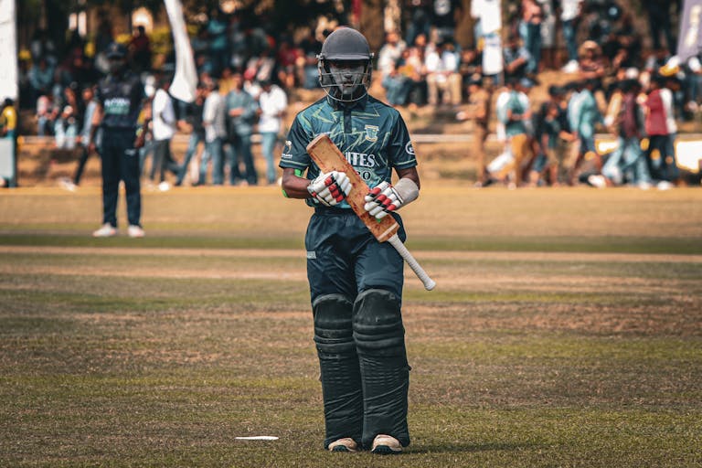 Iplleague2026 Cricketer with helmet and bat ready to play on the field during a sunny day match.