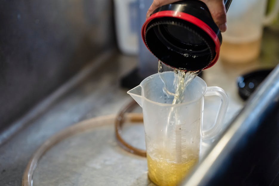 MataRecycler Detailed view of water being poured into a measuring cup, perfect for illustrating precision in liquid measurement.