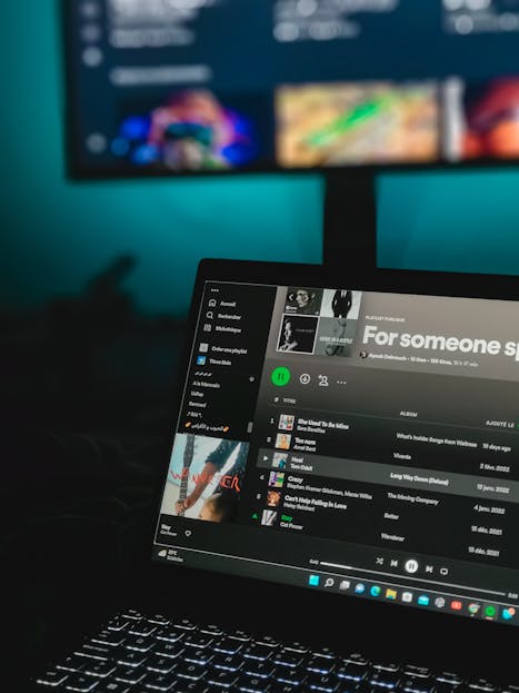 Laptop displaying a music playlist on a streaming service screen.