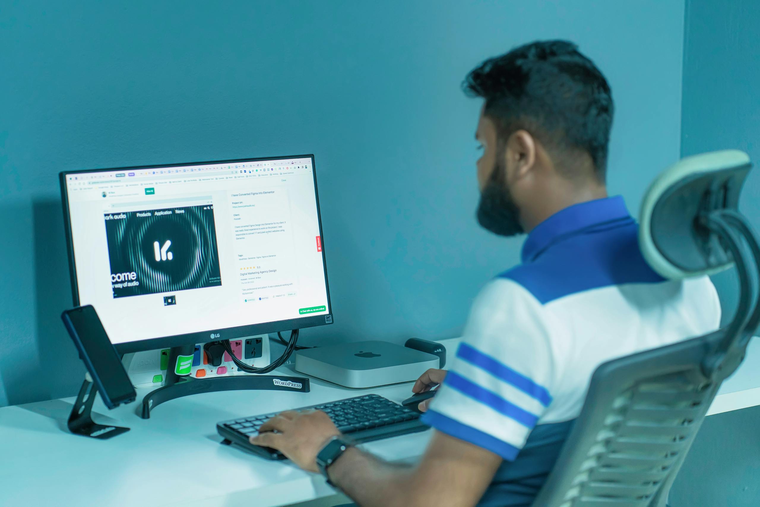 Kongotech Man using a desktop computer with modern tech setup in a professional office environment.