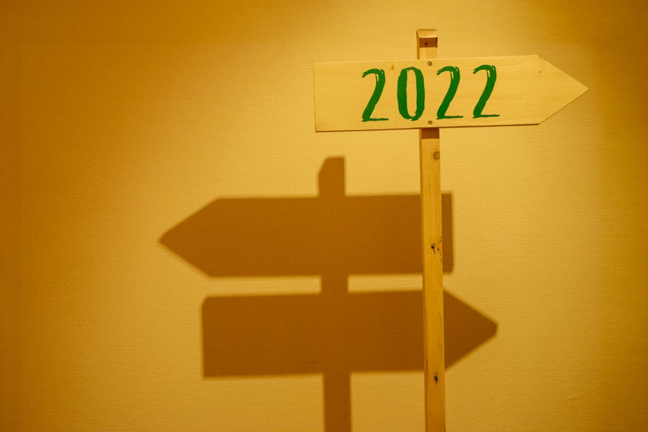 IPLLeague2026 Wooden signpost displaying '2022' with shadow cast on a wall in warm lighting.