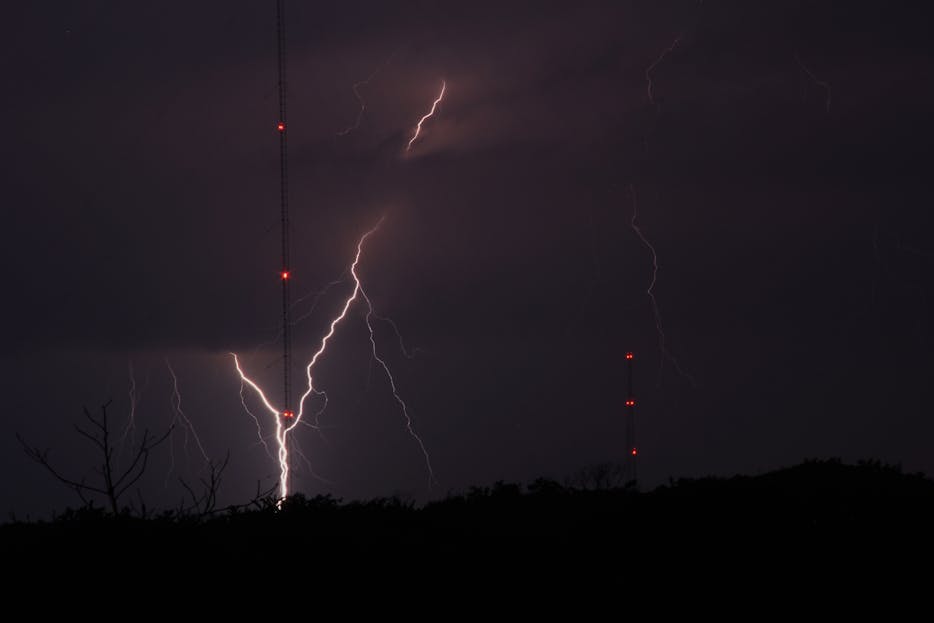 Petir108win.online Captivating image of lightning striking near radio towers during a stormy night in Wildwood Crest, NJ.