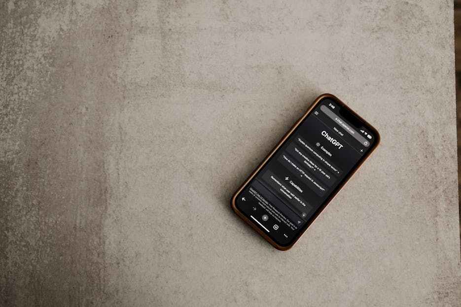 Century Link Close-up of a smartphone with the ChatGPT app open, highlighting AI technology on a textured surface.
