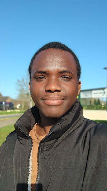 Berniece Julien Close-up of a smiling man outdoors with clear blue sky.