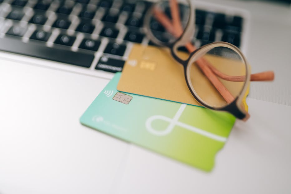 Century Link Close-up of eyeglasses and credit cards on a laptop, emphasizing finance and technology.
