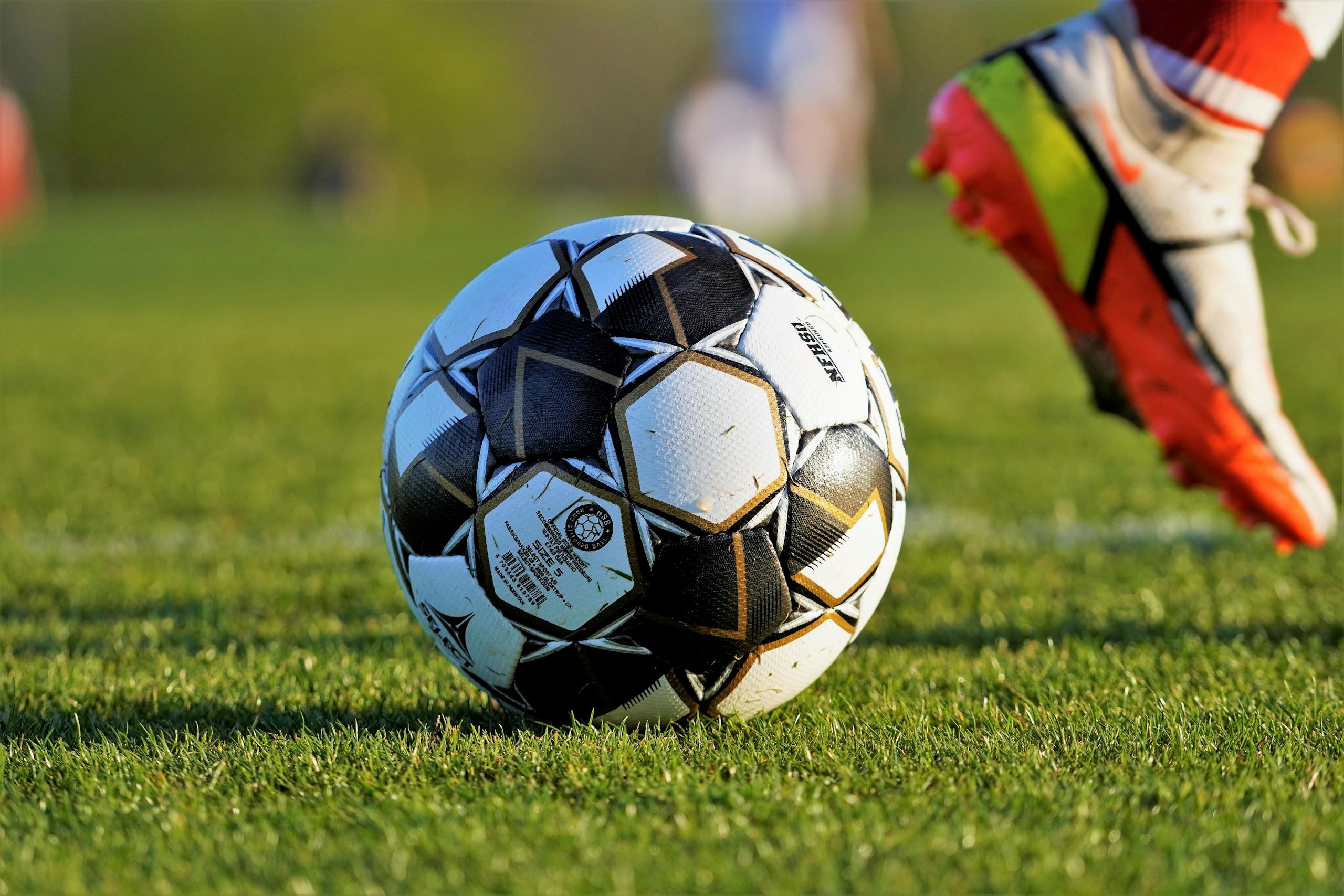 Streameast Soccer Close-up of soccer ball and player's foot during match on grassy field.