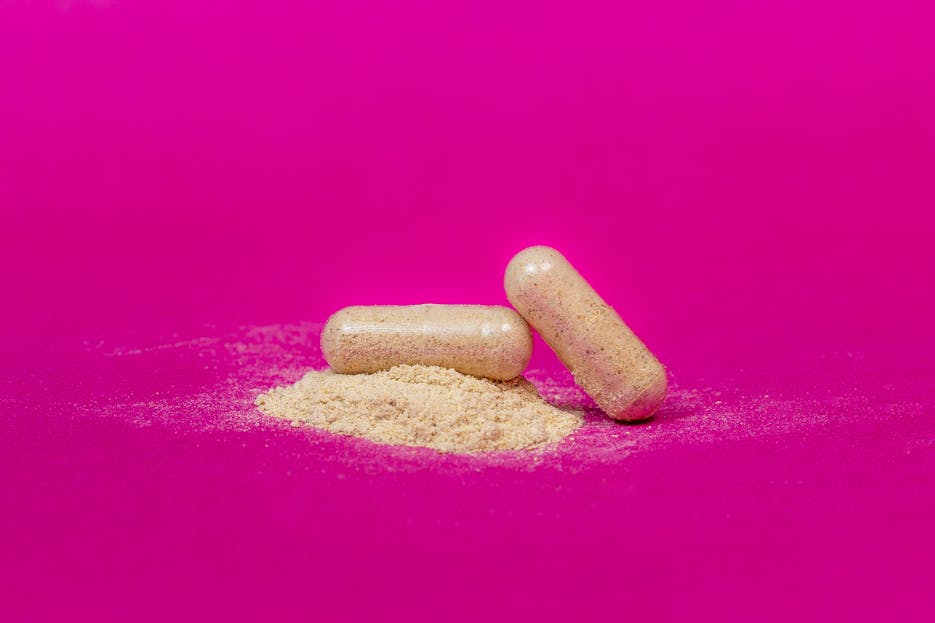 CenturyLinkOnline.com Close-up of two supplement capsules and powder on a vibrant pink background.